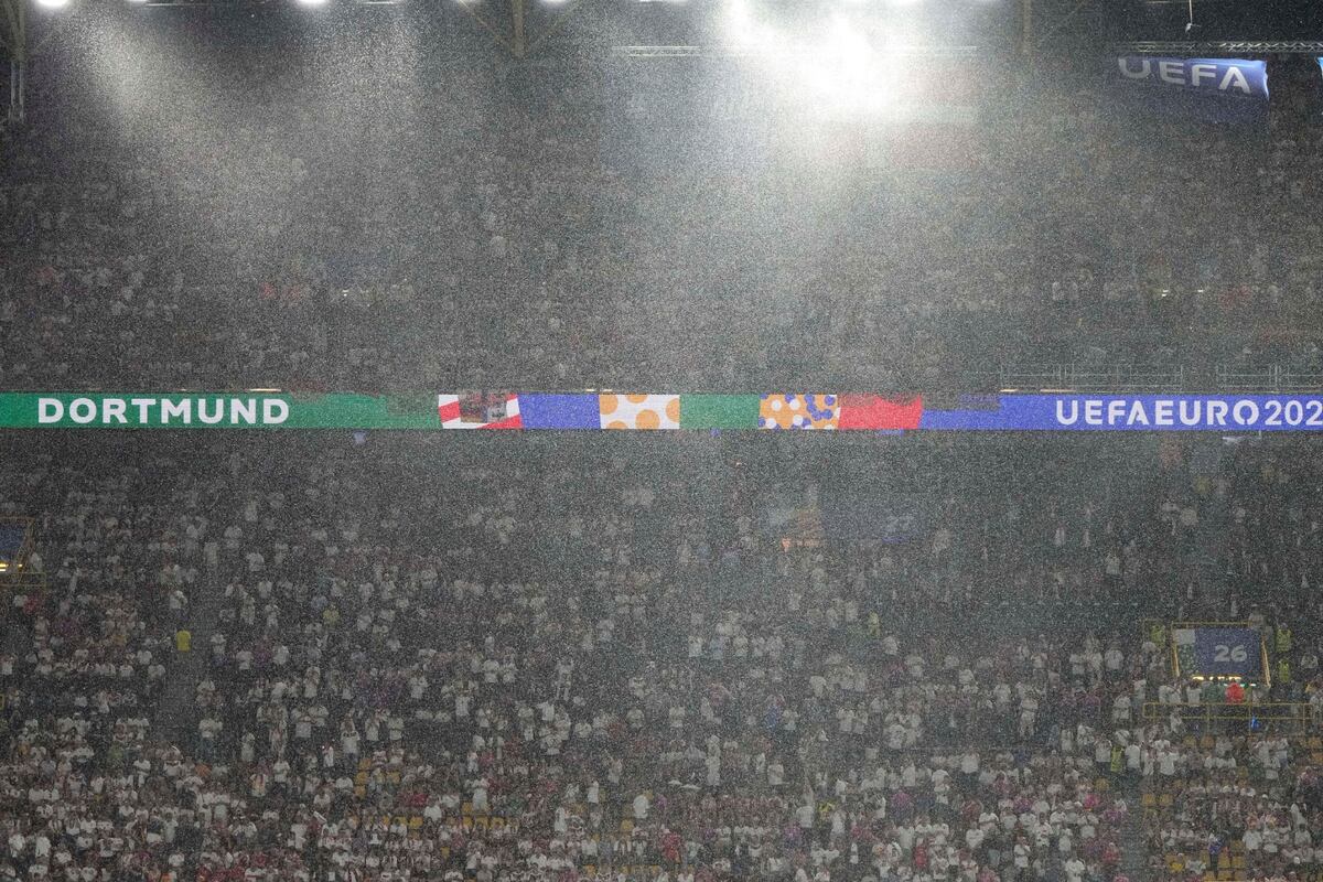 Lluvia en el partido Alemania y Dinamarca que obligo a frenar el juego (AP)