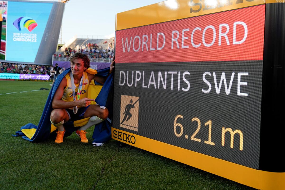 Armand Duplantis, enfundado en los colores de su país, muestra orgulloso el récord mundial de salto con garrocha que estableció en Eugene. (AP)