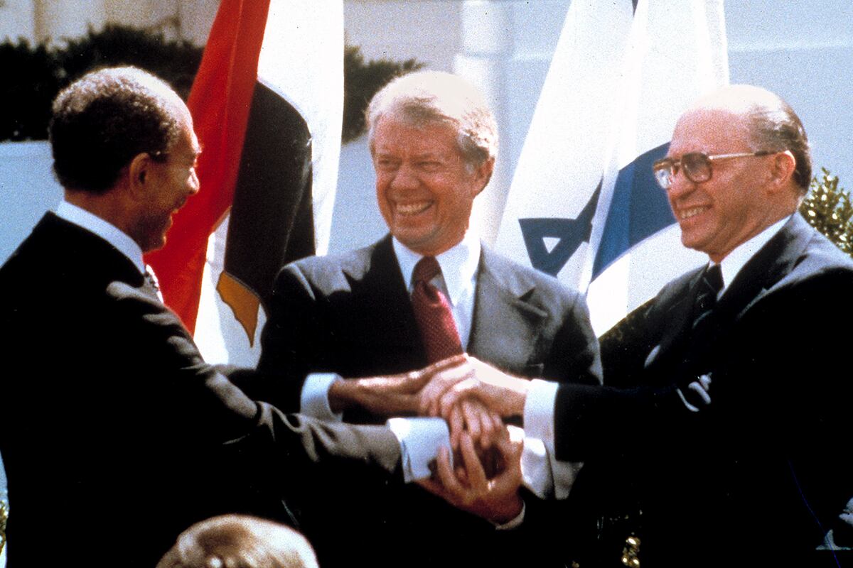 En esta fotografía de archivo tomada el 26 de marzo de 1979, el presidente egipcio Anwar Sadat (izquierda), el presidente estadounidense Jimmy Carter (centro) y el primer ministro israelí Menachem Begin se dan la mano en el jardín norte de la Casa Blanca mientras completaban la firma del tratado de paz entre Egipto e Israel. Cuando el primer ministro israelí Menachem Begin estrechó la mano del presidente egipcio Anwar Sadat en el jardín de la Casa Blanca el 26 de marzo de 1979, los israelíes comunes y corrientes vieron no sólo el fin de la guerra con su vecino más grande, sino también la esperanza de establecer relaciones cálidas con la gente de al lado. Las cosas no han funcionado del todo de esa manera. Esta semana, los países conmemoran el 30º aniversario de lo que en Israel se conoce como la "paz fría". (Foto AP/Bob Daugherty, Archivo)