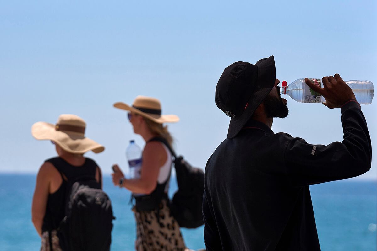 Un turista bebe agua en un día caluroso en la playa de Barcelona, España, el 2 de julio de 2025. (Foto AP/Emilio Morenatti, Archivo)