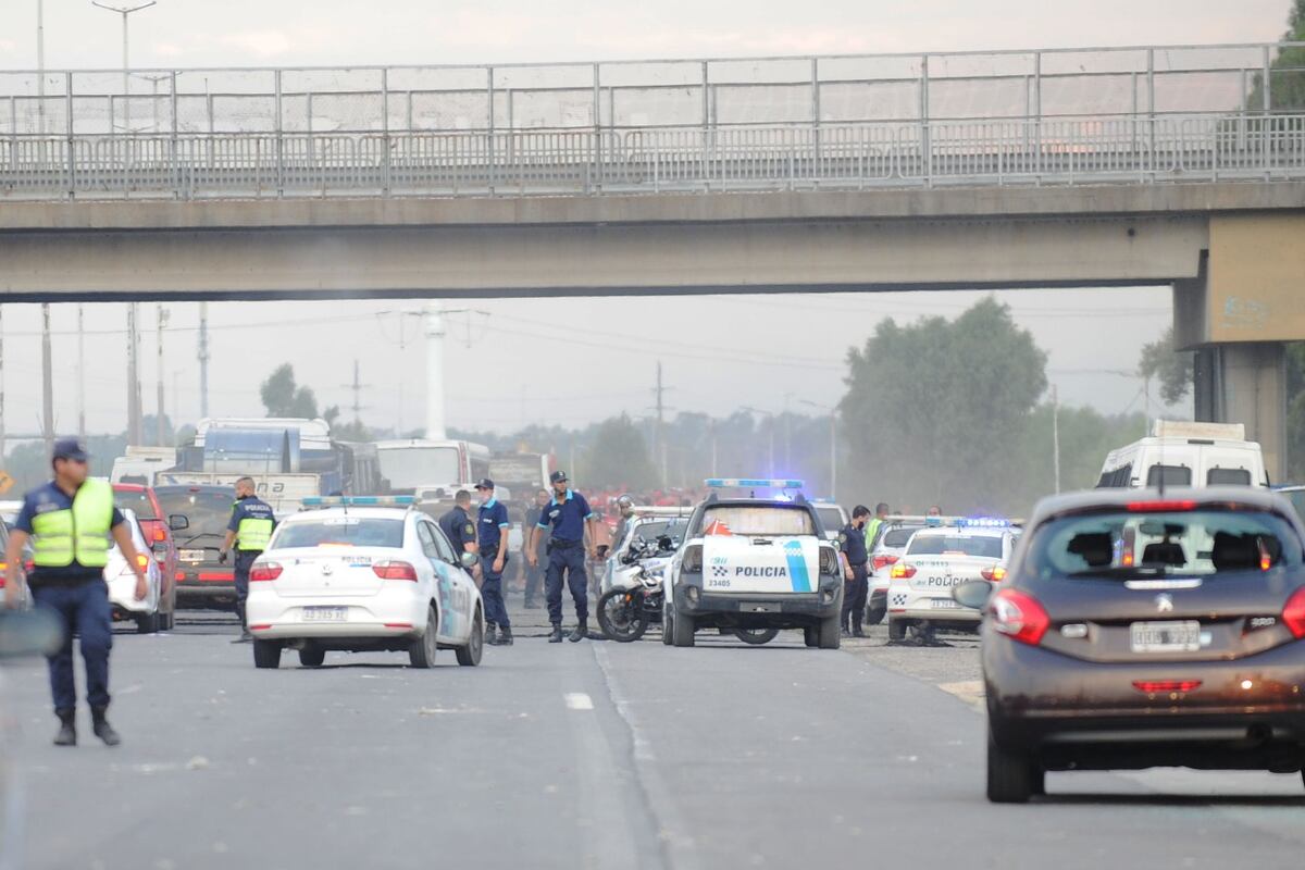 Incidentes entre la barra de Independiente y piqueteros en la autopista entre Buenos Aires y La Plata. (Fotografías de Clarín)