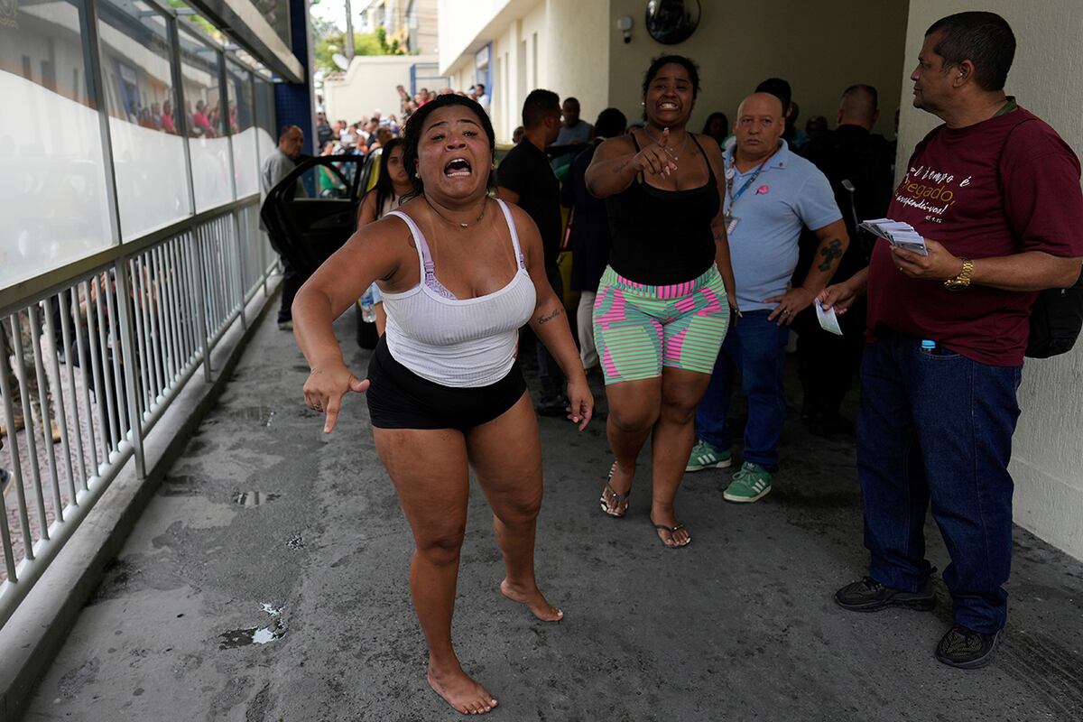 Personas protestan frente al Hospital Getulio Vargas poco después de que la policía trasladara a sus familiares por lesiones sufridas durante un operativo policial contra presuntos narcotraficantes en la favela Complexo do Alemao, donde opera la organización criminal "Comando Vermelho", en Río de Janeiro, el martes 28 de octubre de 2025. (Foto AP/Silvia Izquierdo)