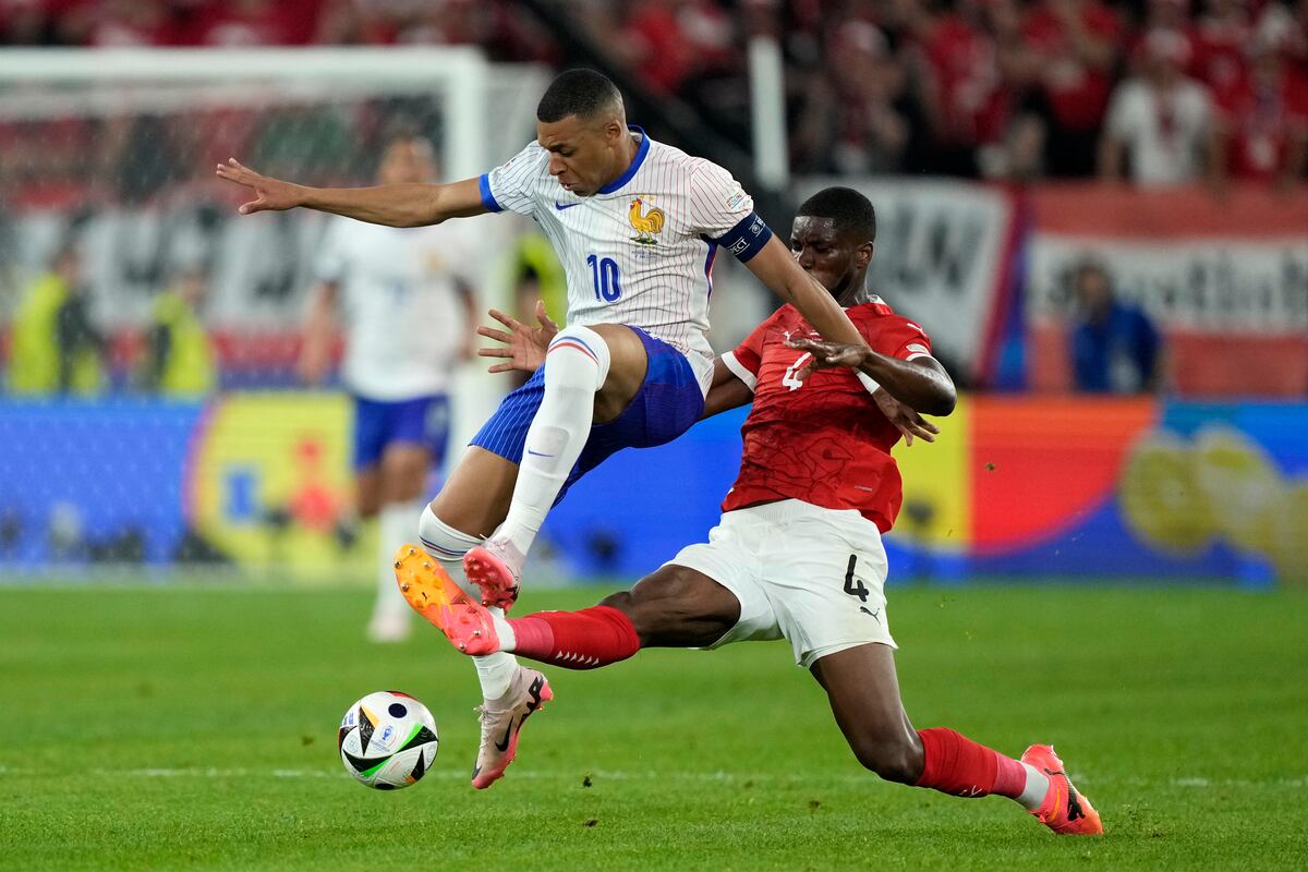 El austriaco Kevin Danso (derecha) sale al paso del francés Kylian Mbappé en el partido por el Grupo D de la Eurocopa, el lunes 17 de junio de 2024, en Duesseldorf. (AP Foto/Martin Meissner)