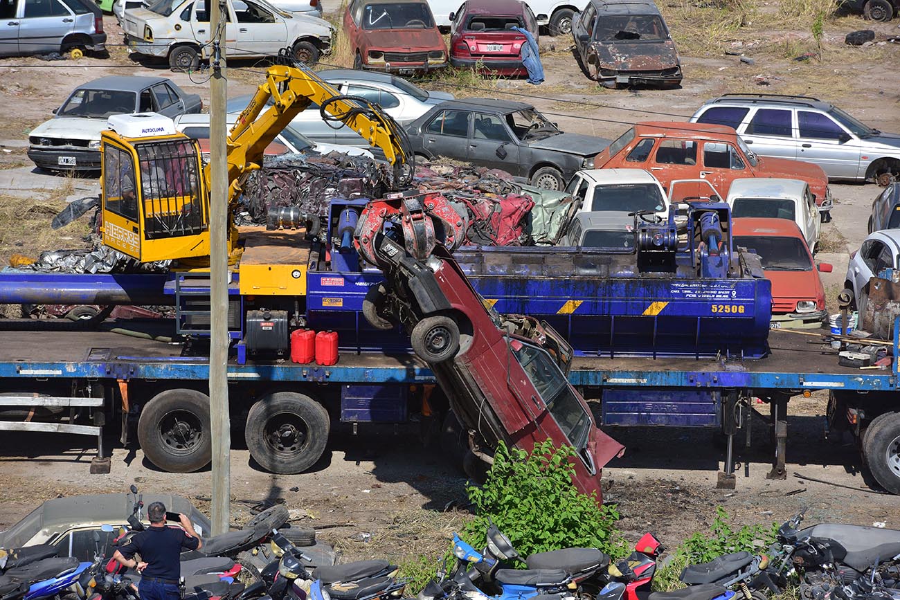 El brazo levanta un Renault 9 para introducirlo en la compactadora (José Gabriel Hernández / La Voz)