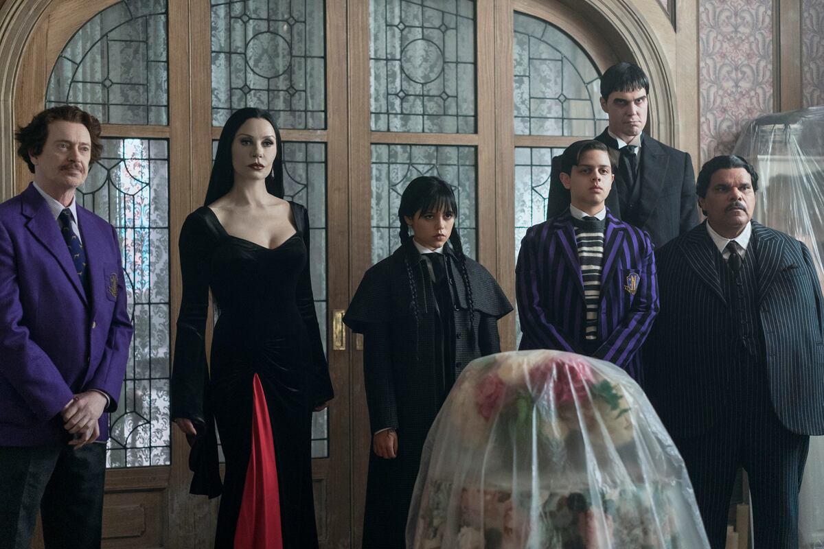 Steve Buscemi (Barry Dort), Catherine Zeta-Jones (Morticia Addams), Jenna Ortega (Merlina), Isaac Ordoñez (Pugsley Addams), Joonas Suotamo (Lurch) y Luis Guzmán (Gómez Addams), en un pasaje del episode 201 de "Merlina". (Jonathan Hession/ Netflix)