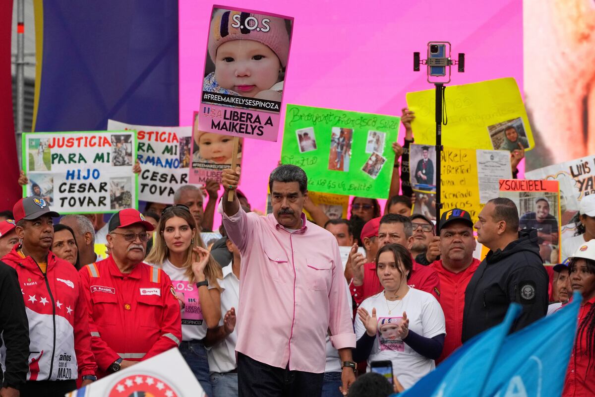 El presidente venezolano, Nicolás Maduro, con un cartel con la imagen de Maikelys Espinoza, una niña de dos años en custodia de Estados Unidos después de que sus padres fueran deportados de forma separada, en un acto por el Día de los Trabajadores en Caracas, Venezuela, el jueves 1 de mayo de 2025. (AP Foto/Ariana Cubillos)