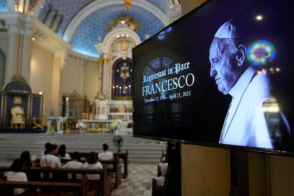 Una imagen del difunto Papa Francisco se muestra mientras los devotos rezan en una iglesia en la ciudad de Quezón, Filipinas, el lunes 21 de abril de 2025. (Foto AP/Aaron Favila)