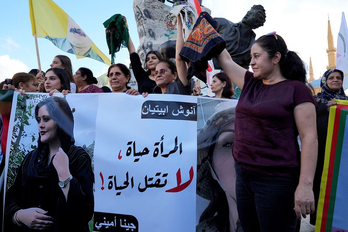 Mujeres activistas kurdas sostienen pañuelos en la cabeza y un retrato de la mujer iraní Mahsa Amini, en árabe que dice: "La mujer es vida, no maten la vida".( Foto: AP)