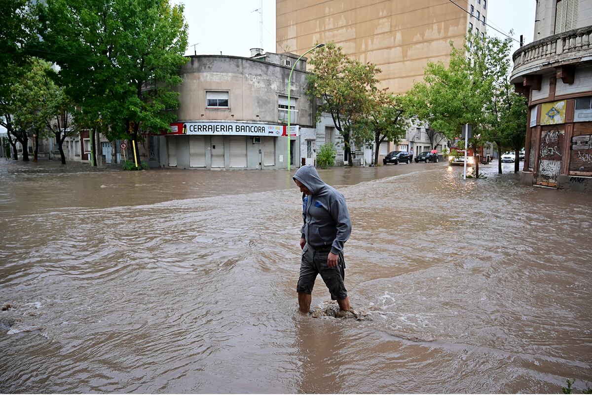 Una persona camina por una calle inundada después de la tormenta en Bahía Blanca. (AP)
