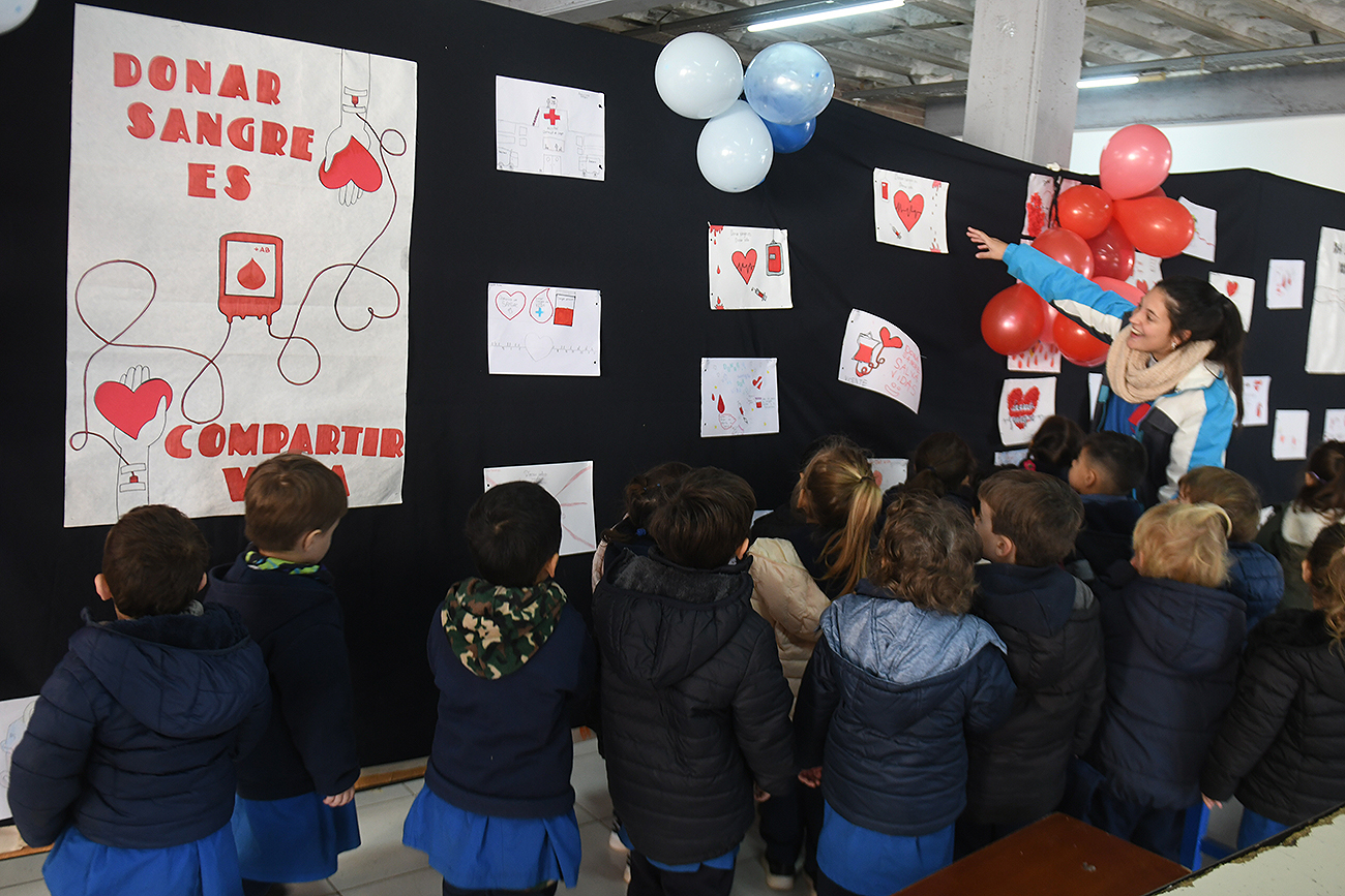 Los alumnos de jardín de infantes repartieron corazones rojos en una recorrida por el SUM de la escuela. (Ramiro Pereyra / La Voz)