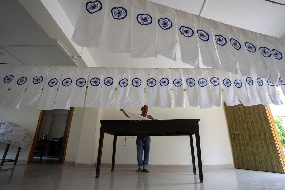  Un hombre trabaja en una bandera nacional india en subproducción para secarla en una oficina antes del Día de la Independencia en Gauhati (AP Photo/Anupam Nath)
