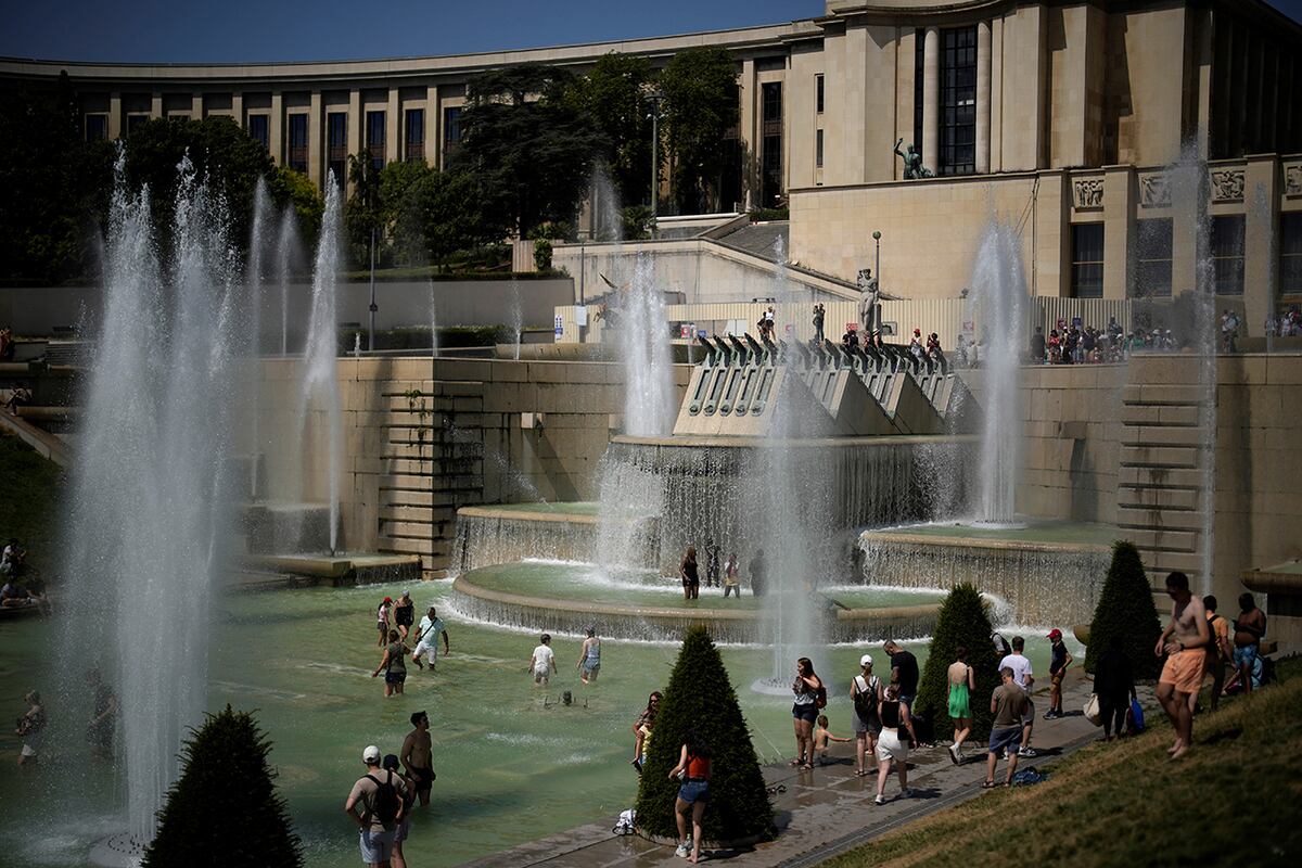 La gente se refresca en las fuentes de los jardines del Trocadero en París mientras Europa sufre una ola de calor inusualmente extrema. (Foto AP/Christophe Ena)
