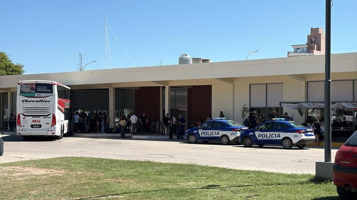 El colectivo parado por orden municipal en la terminal de Oliva y la presencia de móviles policiales (Gentileza: familias afectadas)