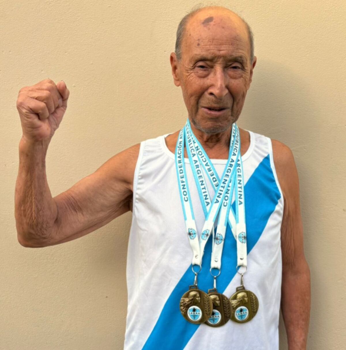 Hugo Britos, de 90 años, con las tres medallas que ganó en el Grand Prix Internacional del Mercosur. El oriundo de Bell Ville, Córdoba, obtuvo el primer puesto en las categorías de 100, 400 y 800 metros llanos. (Gentileza Carlos Durán)