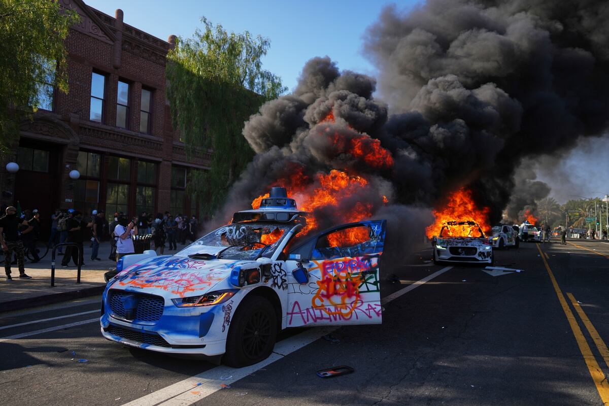Varios taxis de Waymo arden cerca del Centro Metropolitano de Detención en el centro de Los Ángeles, el domingo 8 de junio de 2025, tras la protesta del día anterior contra las redadas migratorias. (AP Foto/Eric Thayer)
