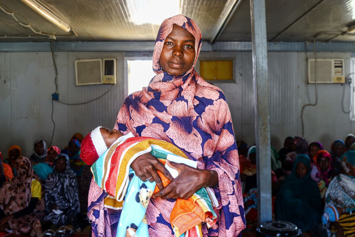 Rehab Musa sostiene a su bebé después de una consulta de seguimiento con un médico en el centro de salud que MSF gestiona en el campo de personas desplazadas de Kalma. Darfur del Sur, Sudán. (MSF/Abdoalsalam Abdallah)