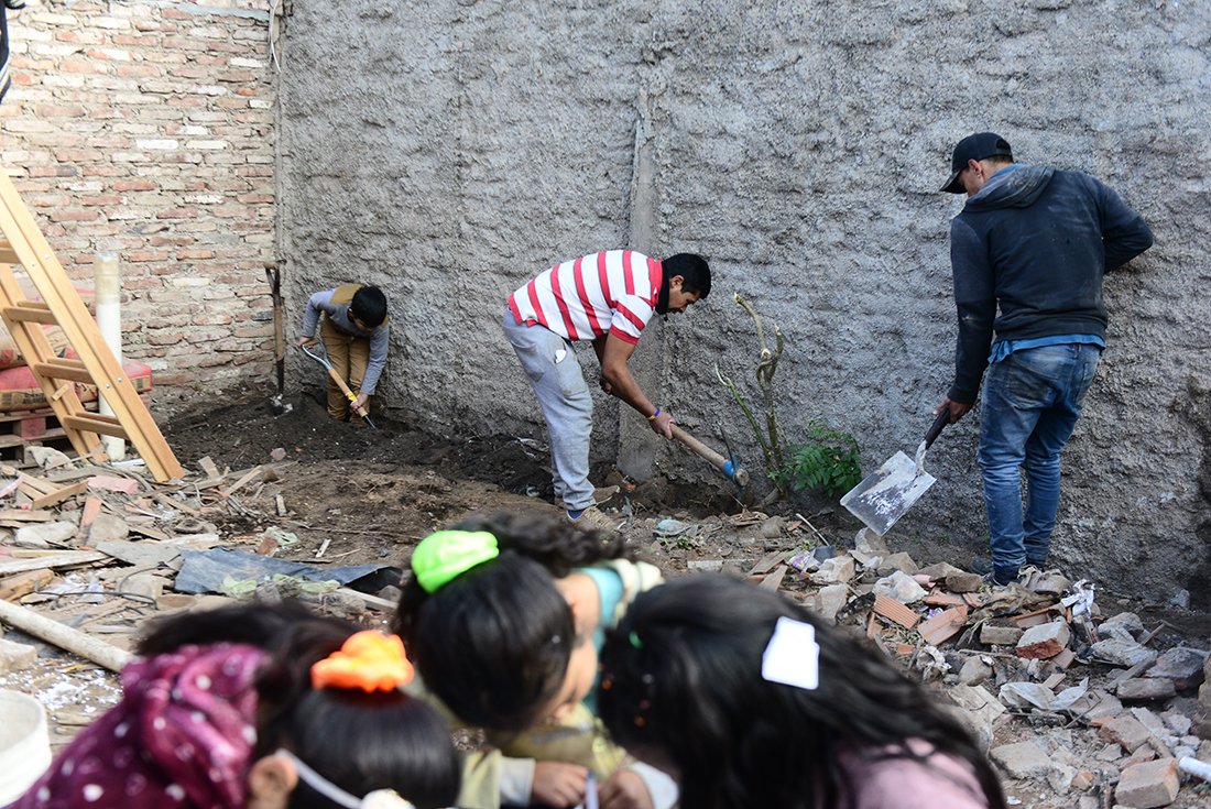Ampliación Ferreyra. Las hijas de Alejandro estudian en el patio mientras el joven prepara el terreno para construir. (José Hernández / La Voz)
