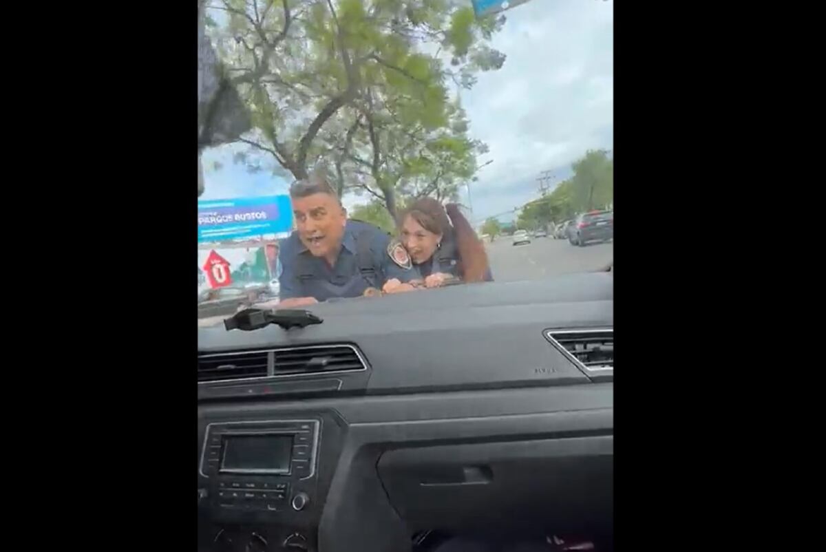 Policías. El gesto de los uniformados siendo arrastrados por el auto (Captura de video).