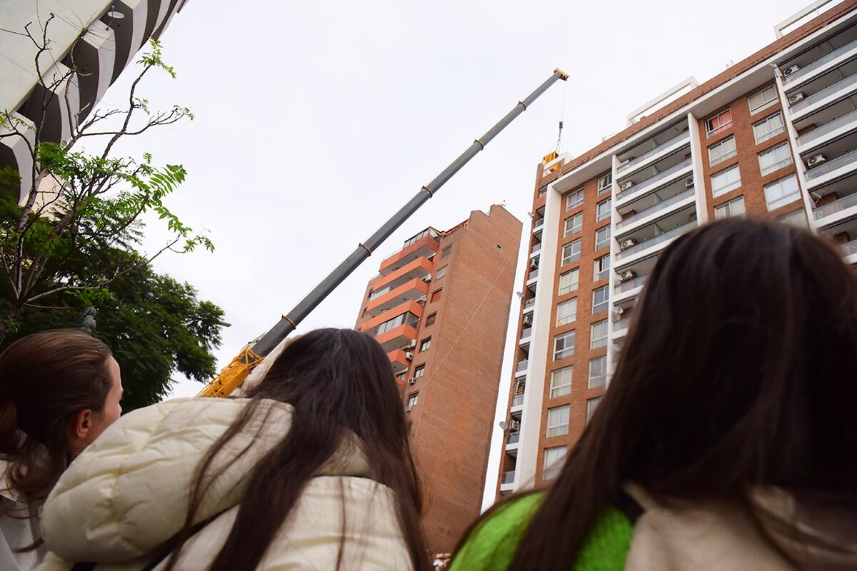 Transeúntes observan las tareas de demolición en el muro del edificio de Güemes. (José Gabriel Hernández / La Voz)