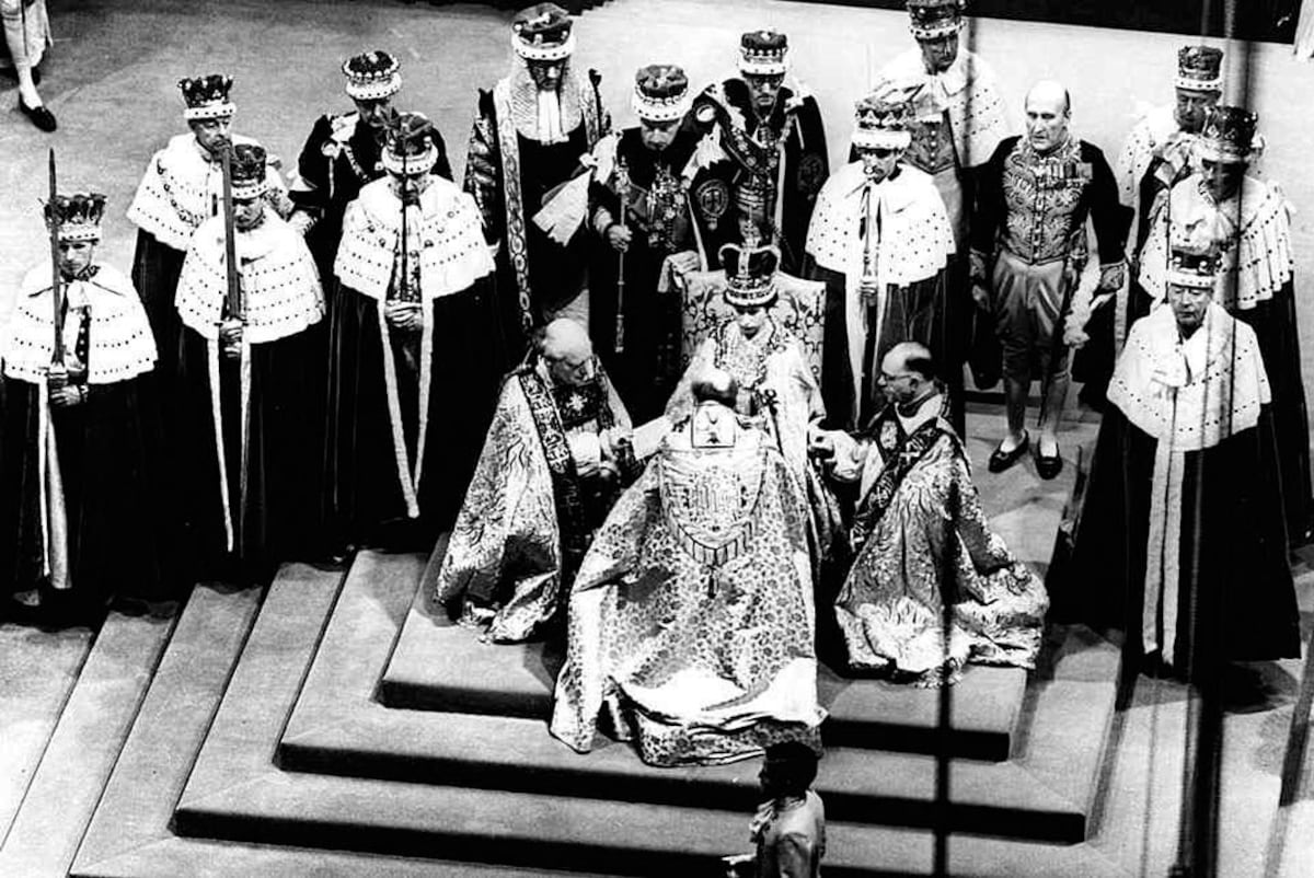 La reina Isabel II, sentada en el trono, recibe la lealtad del arzobispo de Canterbury, centro con espaldas a la cámara, el obispo de Durham, la izquierda y el obispo de Bath y Wells, durante su coronación en la abadía de Westminster, el 02 de junio 1953.