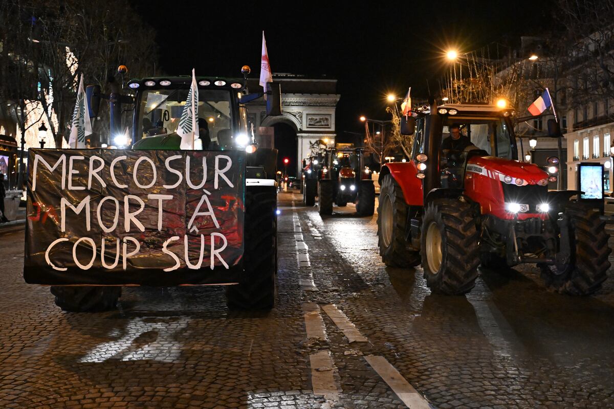 Agricultores conducen sus tractores por la avenida de los Campos Elíseos en protesta por el acuerdo comercial del Mercosur, el martes 13 de enero de 2026 en París. (Foto AP/Emma Da Silva)