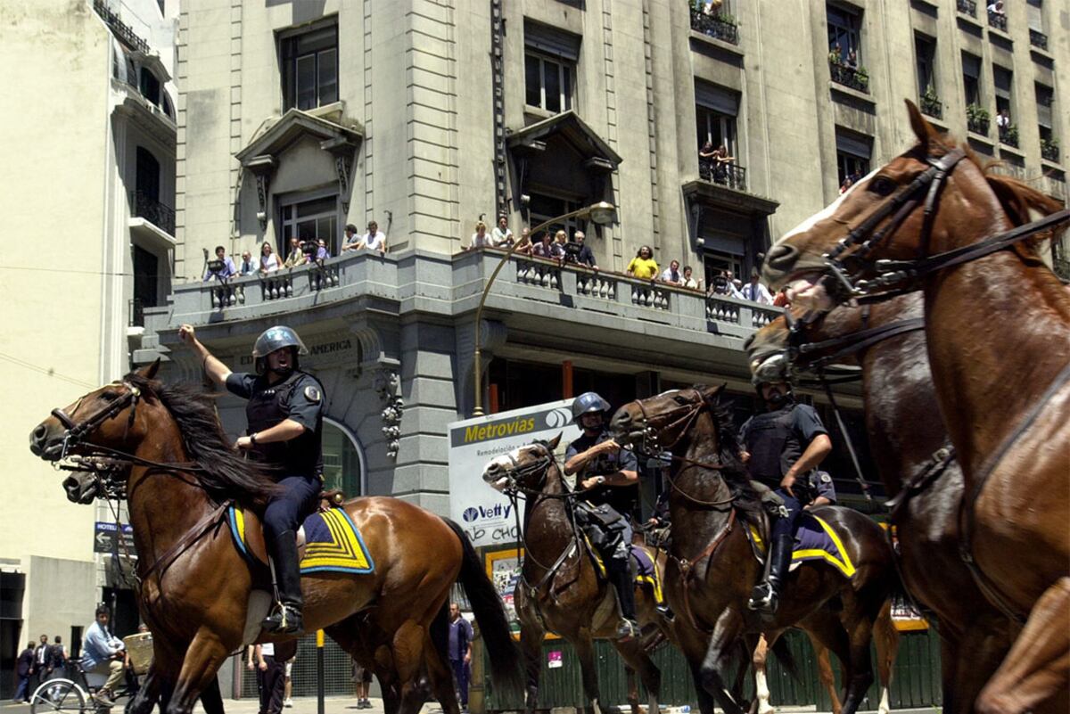 Mounted police officers move in Buenos Aires' Plaza de Mayo, Thursday, Dec. 20, 2001 to clear straggling protesters from the plaza, where tens of thousands of Argentines gathered overnight to express their disgust with the government and nearly four years of recession that has pushed unemployment
to almost 20 percent. The plaza is where the government house, the economy ministry and other key government offices are located. (AP Photo/Walter Astrada)
