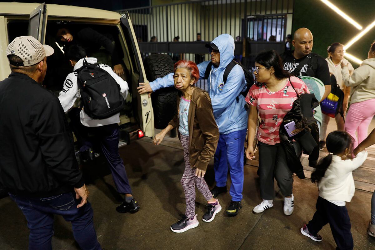 Residentes evacuan un edificio cerca del palacio presidencial de Miraflores tras escuchar explosiones y aviones volando a baja altura en Caracas, Venezuela, el sábado 3 de enero de 2026. (Foto AP/Cristian Hernandez)