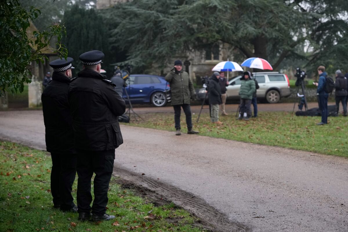 Dos policías y varios medios periodísticos, en la residencia de Sandringham, donde se produjo la detención del príncipe Andrés, el 19 de febrero de 2026.