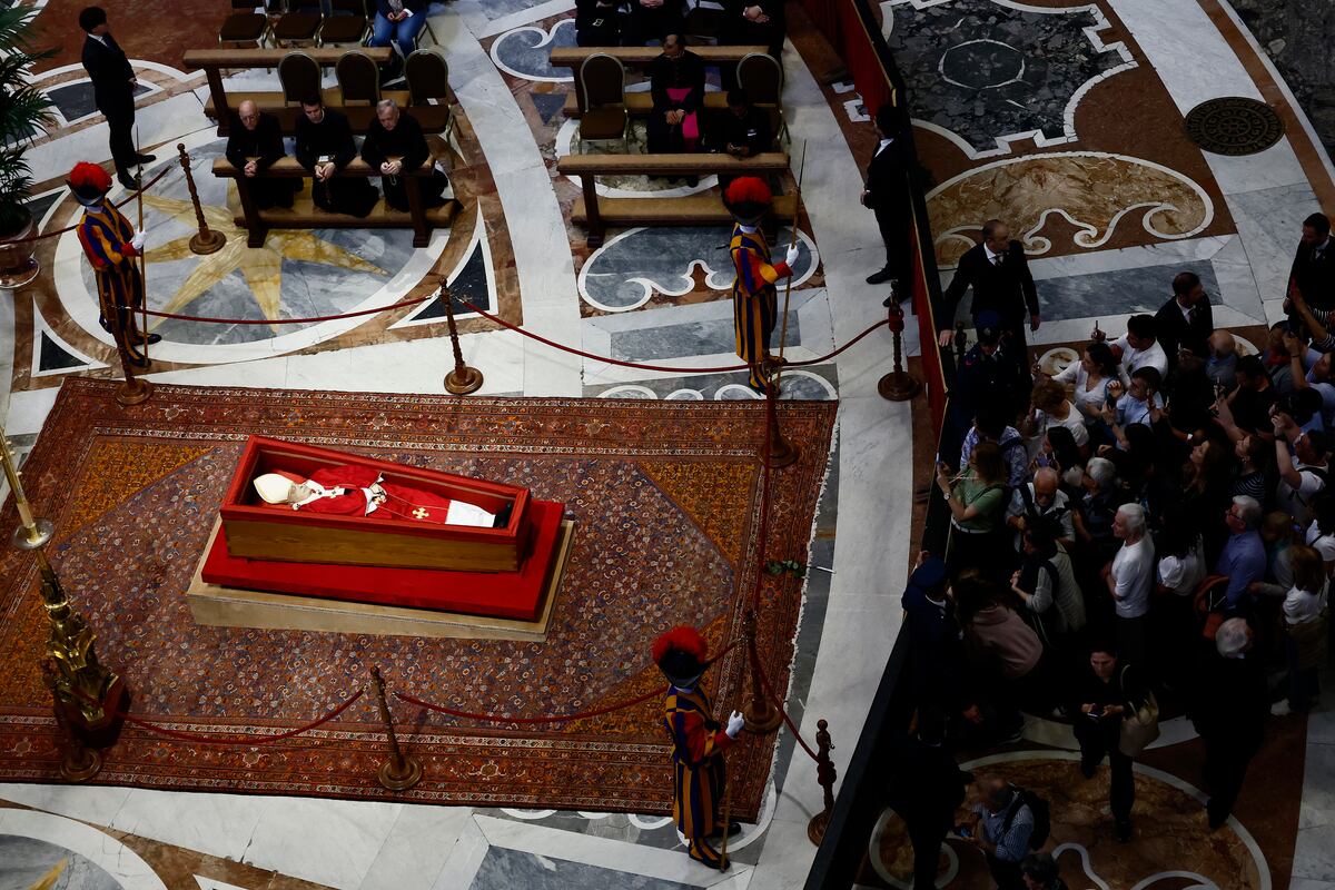 Fieles hacen fila para presentar sus respetos al difunto papa Francisco en la capilla ardiente instalada en la basílica de San Pedro, en el Vaticano, el 23 de abril de 2025. (Cecilia Fabiano/LaPresse vía AP)