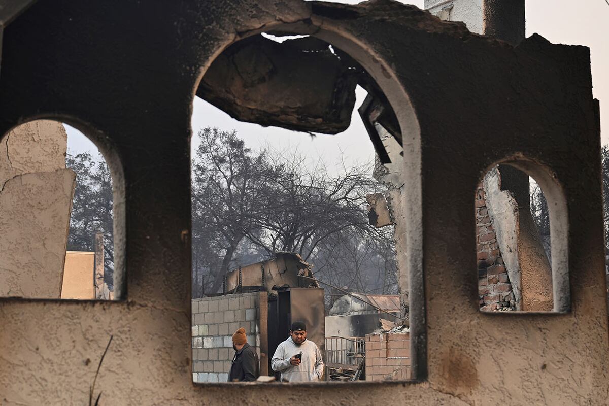 La gente observa las estructuras dañadas después de que el incendio Eaton arrasara en Altadena, California. (AP)