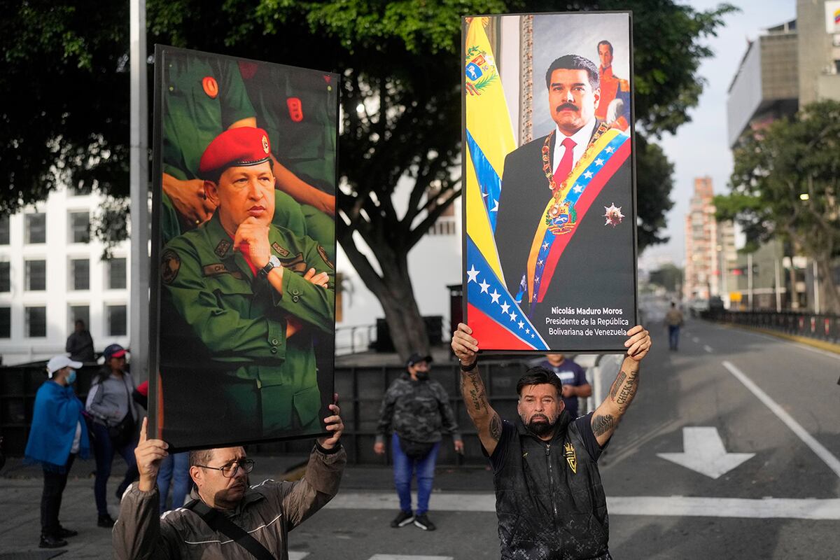 Partidarios del gobierno exhiben carteles del presidente venezolano Nicolás Maduro (derecha) y del expresidente Hugo Chávez en el centro de Caracas, Venezuela, el sábado 3 de enero de 2026, después de que el presidente estadounidense Donald Trump anunciara que Maduro había sido capturado y expulsado del país. (Foto AP/Matias Delacroix)