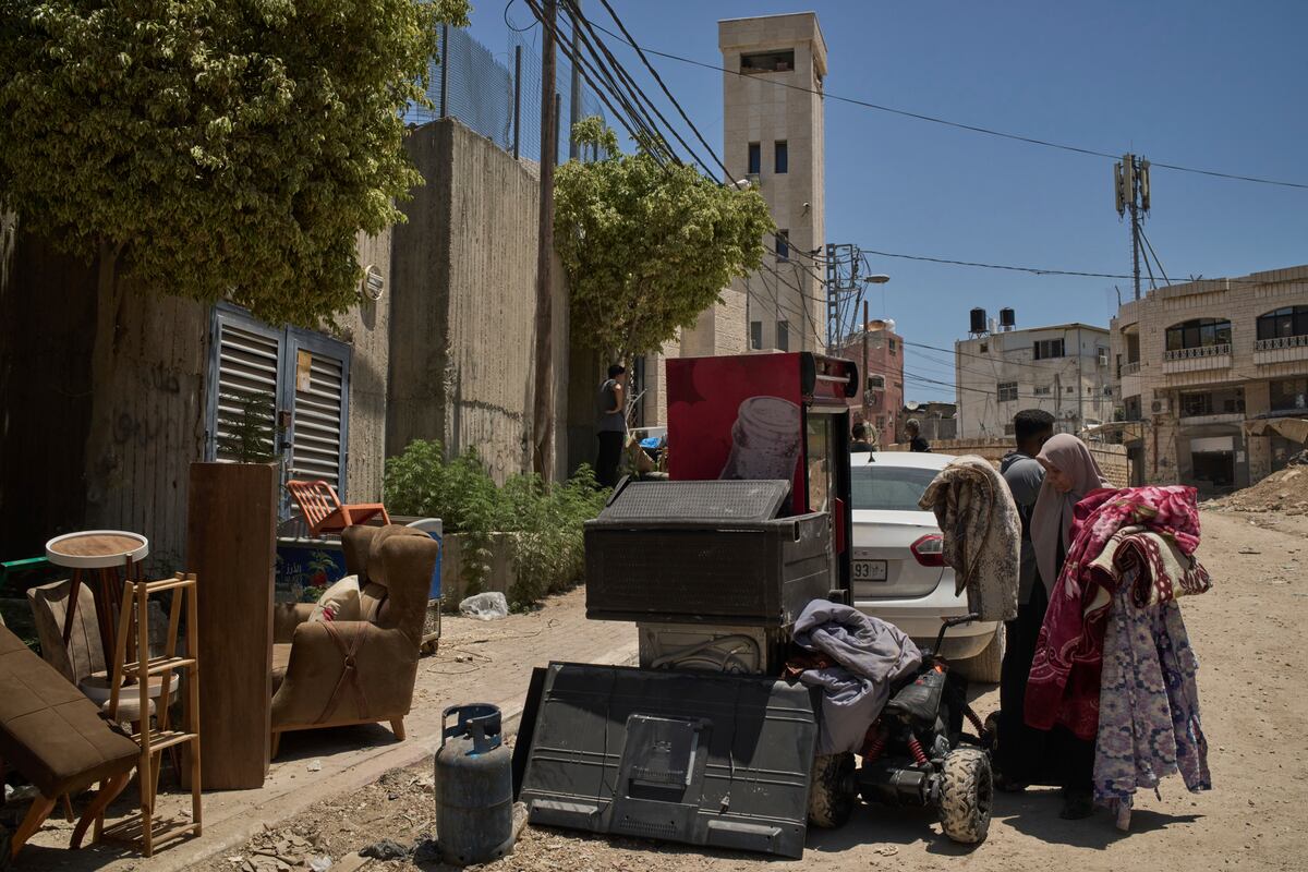 Varios palestinos reúnen sus pertenencias antes de que sus viviendas sean demolidas por las fuerzas israelíes en el campamento de refugiados de Tulkarem en Cisjordania, el miércoles 2 de julio de 2025. (AP Foto/Leo Correa)