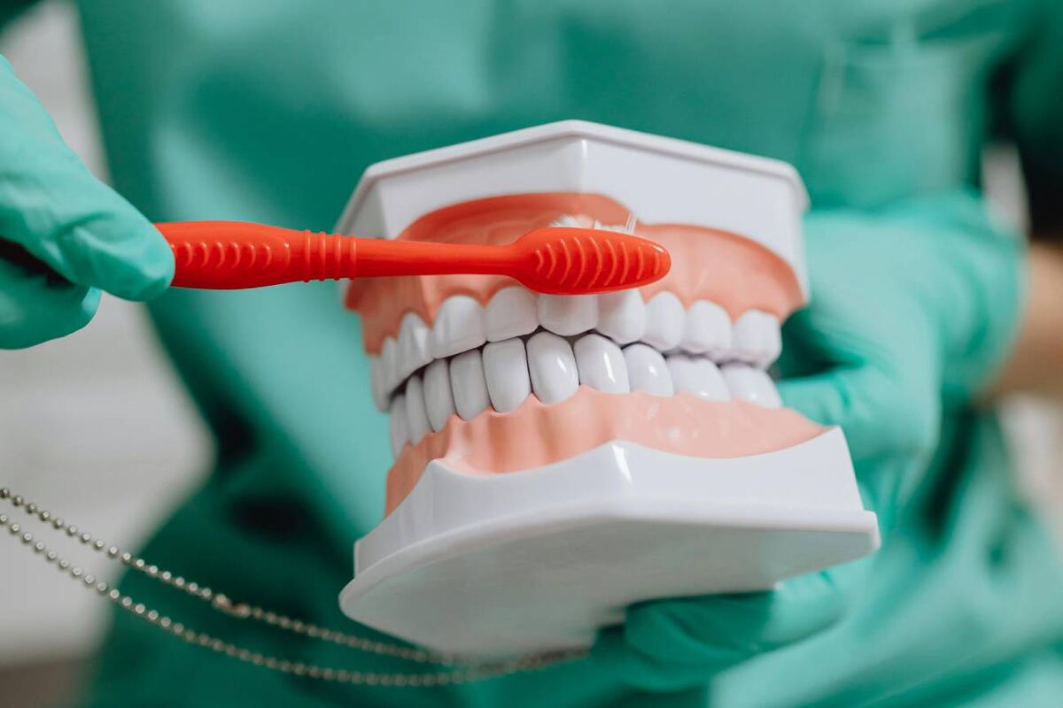 Odontologa enseñando como lavarse los dientes (Pexels)