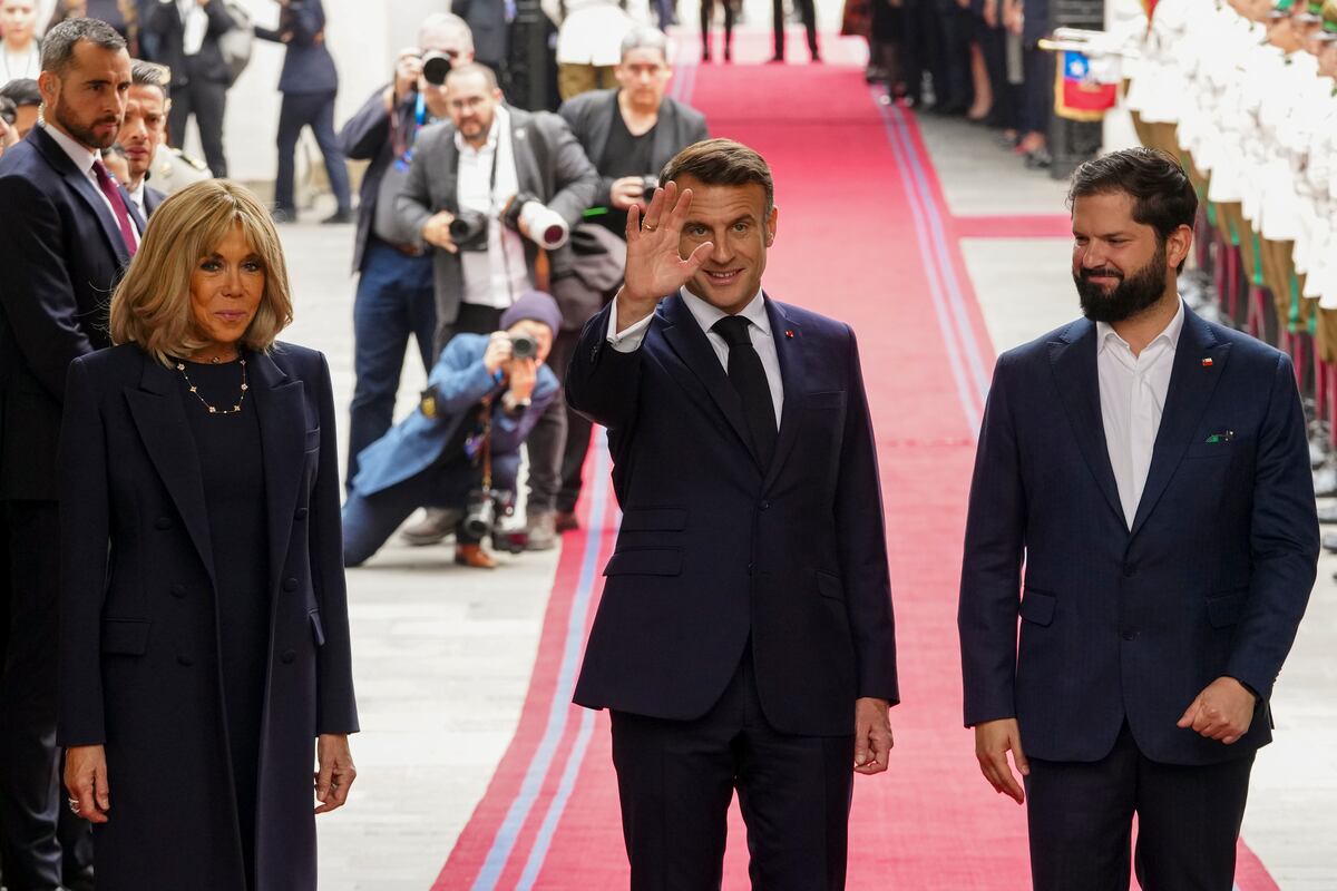 El presidente francés, Emmanuel Macron, saluda acompañado de su esposa Brigitte, en la recepción del presidente chileno, Gabriel Boric, en el palacio presidencial de La Moneda en Santiago, Chile, el miércoles 20 de noviembre de 2024. (AP Foto/Esteban Félix)