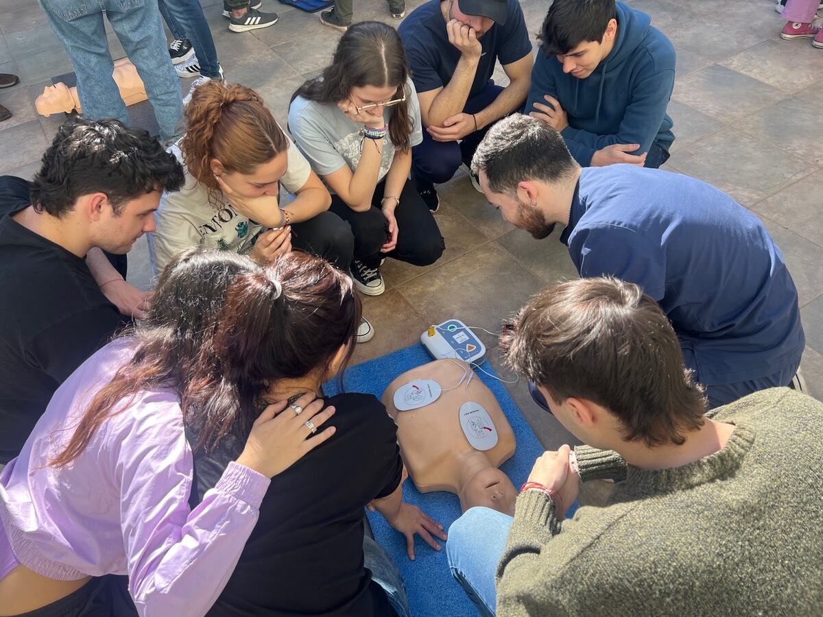 Jóvenes aprendiendo cómo reanimar una persona con el simular móvil de Adaarc.