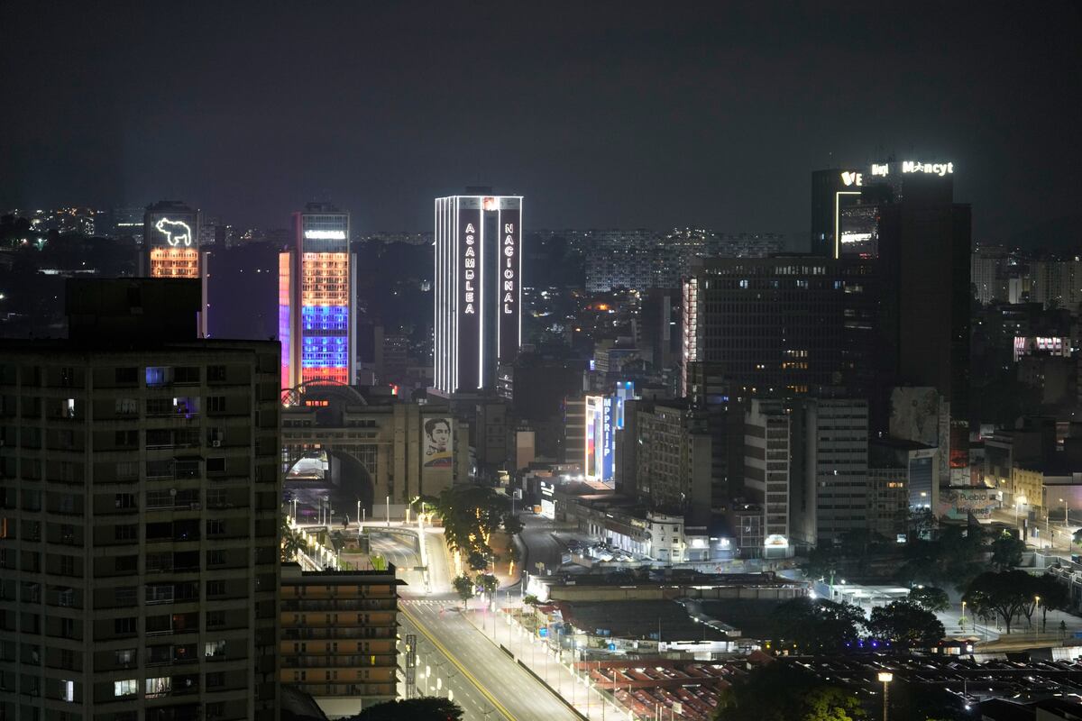 El edificio de la Asamblea Nacional se ilumina en el centro de Caracas, Venezuela, después de que se escucharan explosiones y aviones volando a baja altura, el sábado 3 de enero de 2026. (Foto AP/Matias Delacroix)