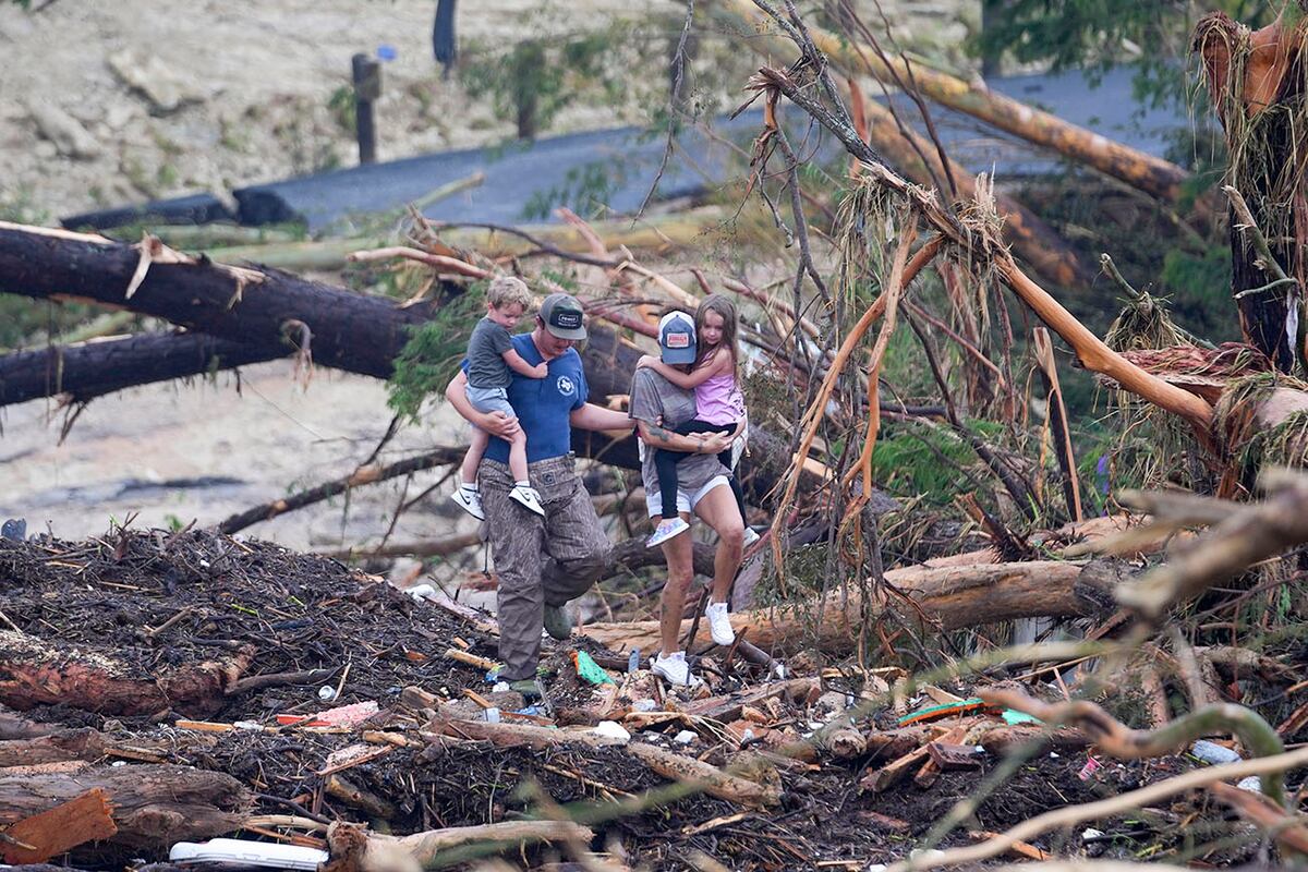 Personas trepan por los escombros de un puente sobre el río Guadalupe tras una inundación repentina que azotó la zona el sábado 5 de julio de 2025 en Ingram, Texas. (Foto AP/Julio Cortez)