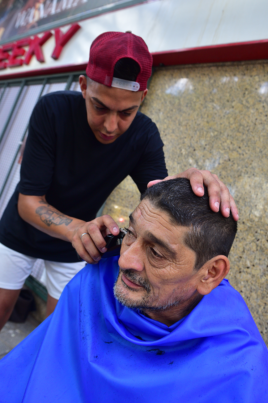 Jairo Rivero García, el cordobés de 29 años que le corta el pelo gratis a la gente al frente del Patio Olmos. (José Gabriel Hernández / La Voz)