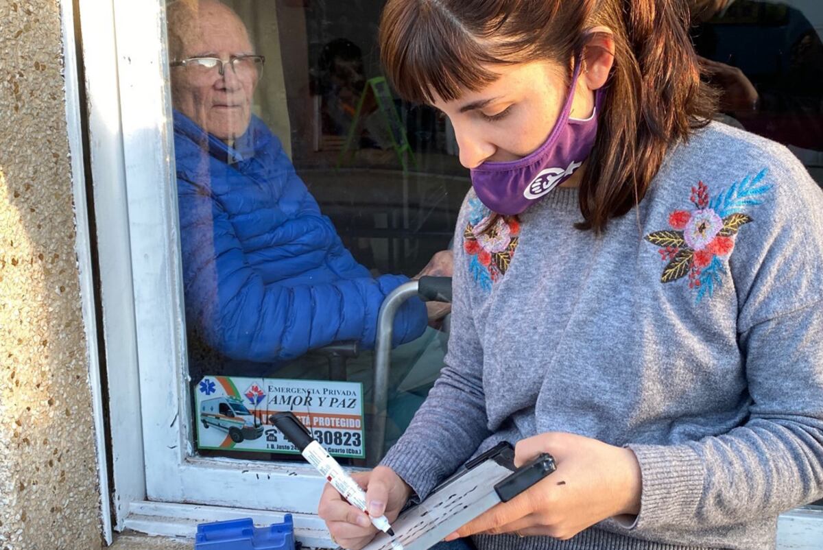 Juliana visita a su abuelo y le escribe a través del vidrio, en una residencia en Río Ciuarto (Tomy Fragueiro)