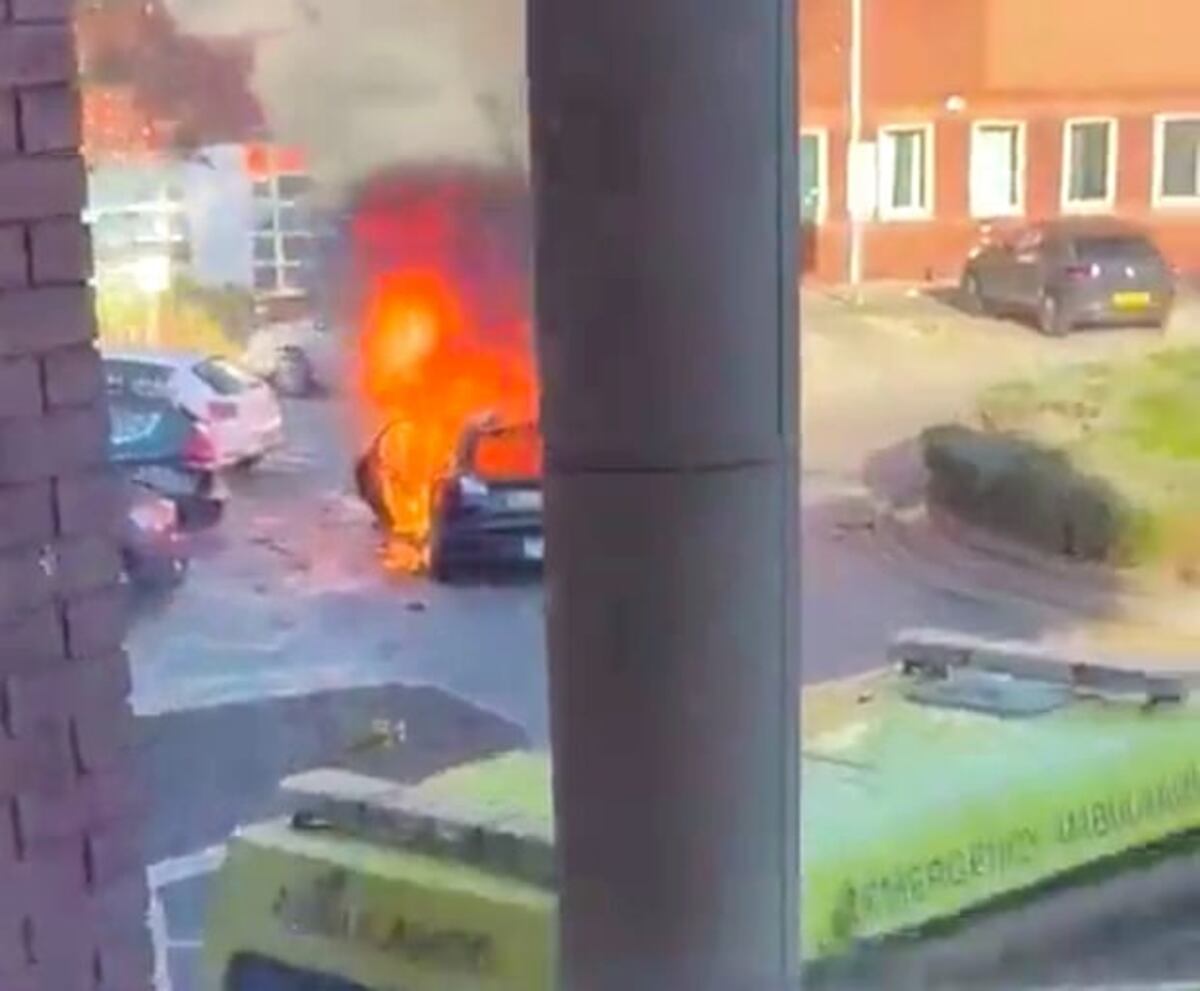 El auto afuera del hospital prendido fuego. (Twitter)