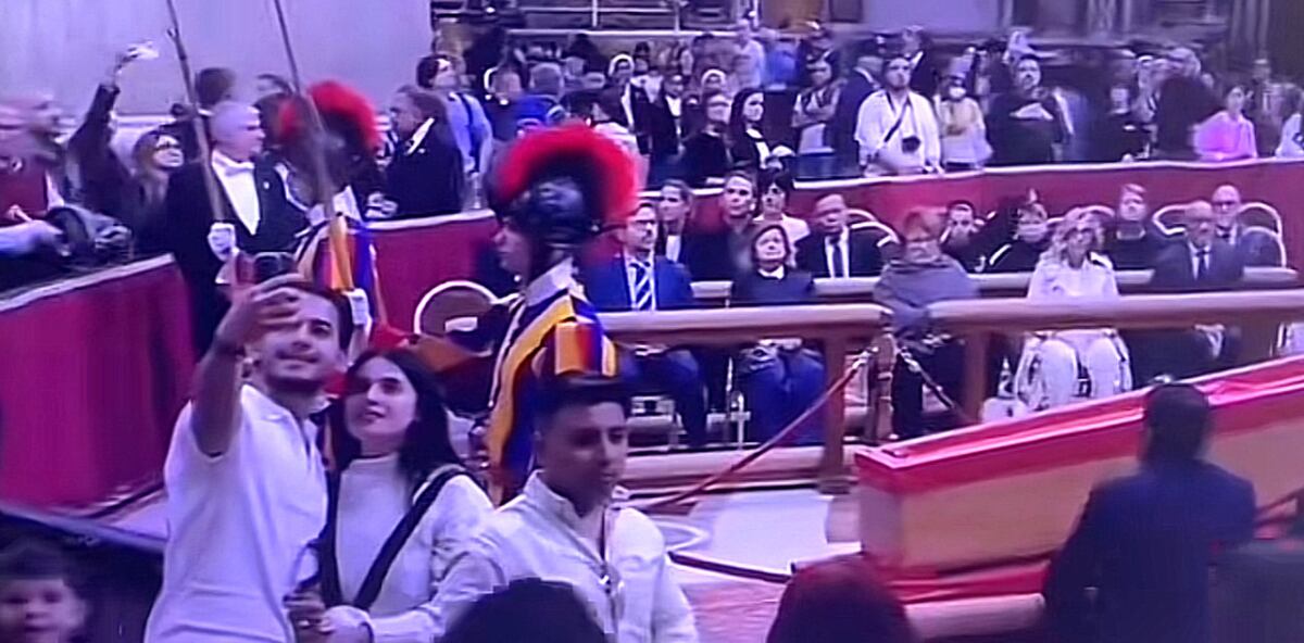 Una pareja se toma una foto ante el féretro del papa Francisco.