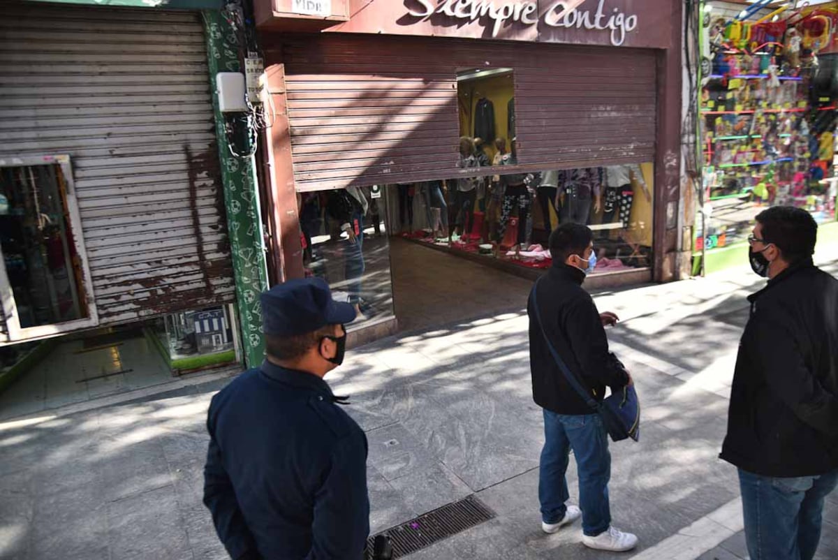 Inspectores municipales y policía hacen bajar las percianas a comerciantes del área peatonal en la ciudad de Córdoba. (Pedro Castillo/ La Voz)