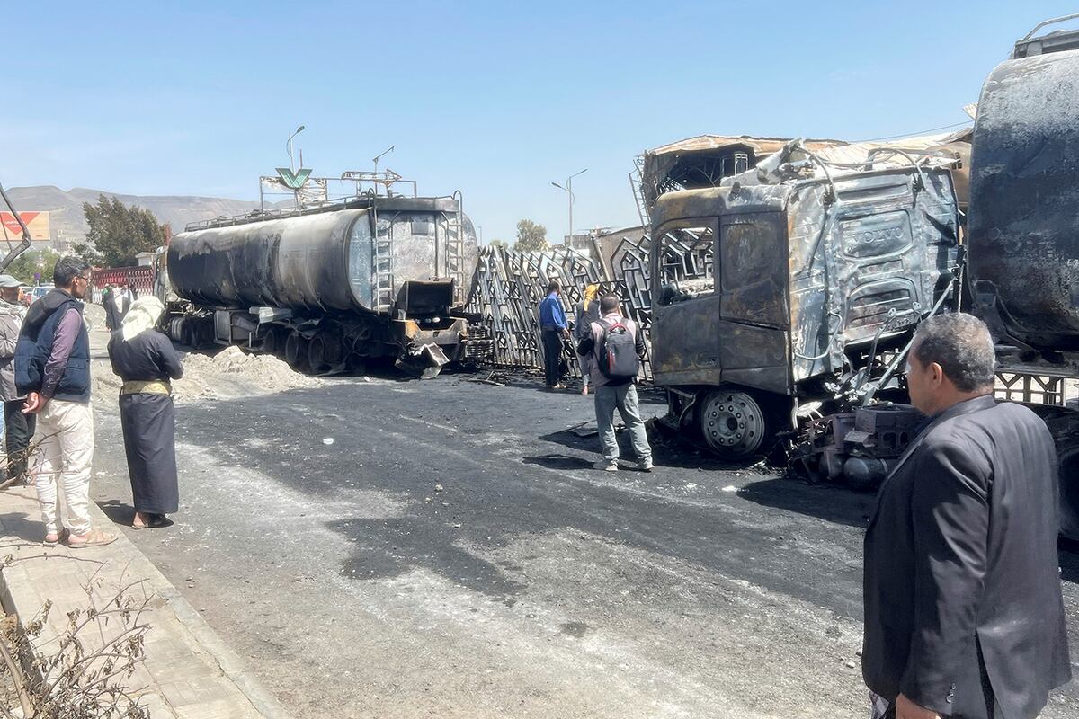 Personas observan vehículos y edificios dañados un día después de los ataques aéreos israelíes contra la principal gasolinera de Saná, Yemen, el lunes 25 de agosto de 2025. (Foto AP)