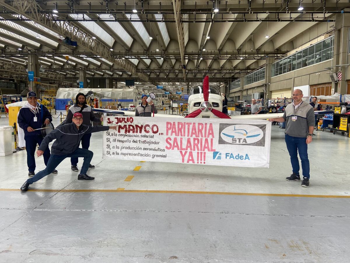 Protesta de los gremios de Fadea, con el avión Malvina detrás. (La Voz)