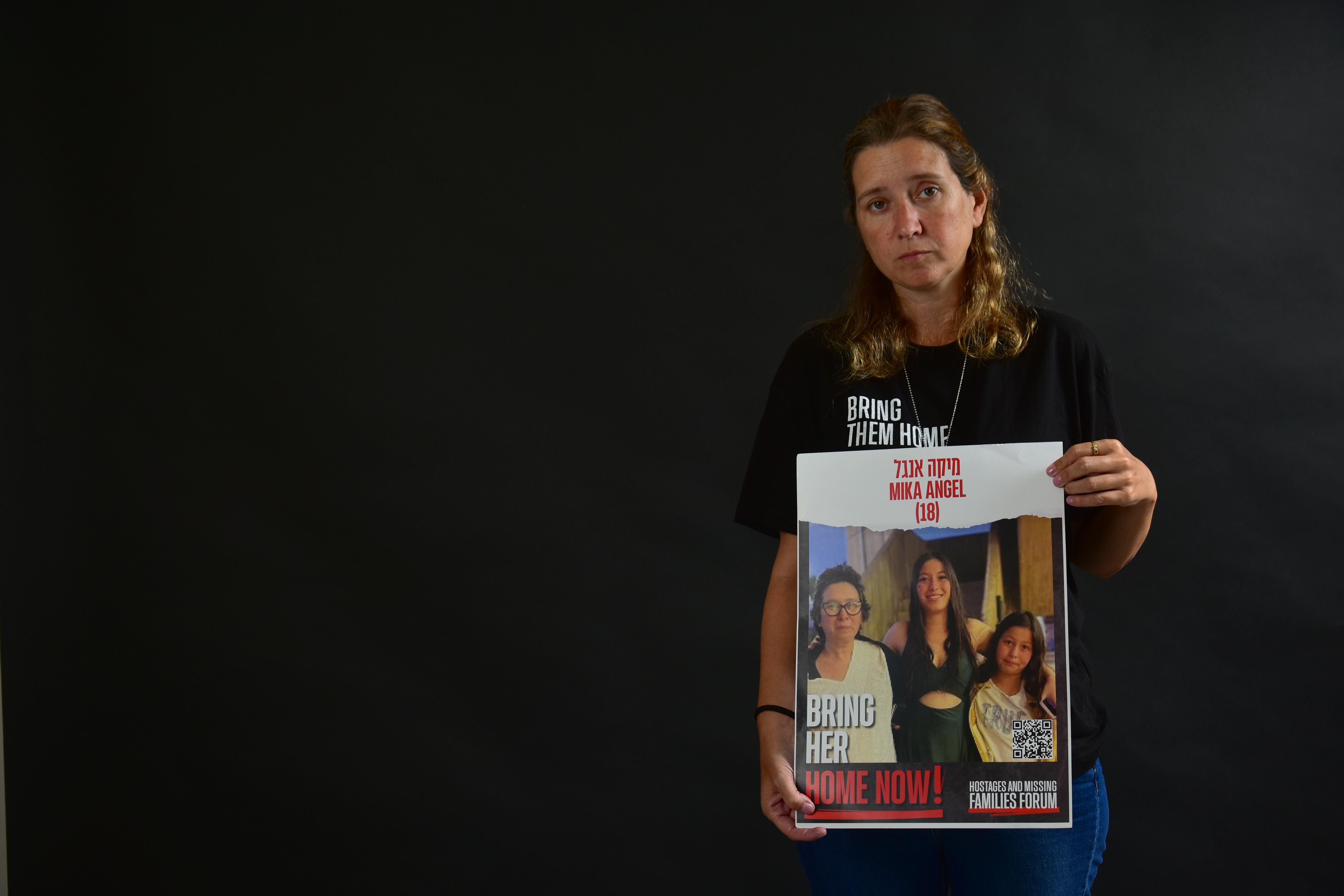 Romina Engelbert, con el cartel en el que se ven su hermana Karina y sus sobrinas Mika y Yuval.